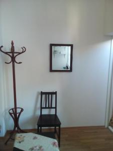 a mirror on a wall next to a chair and a mirror at Brown Amber in Liepāja