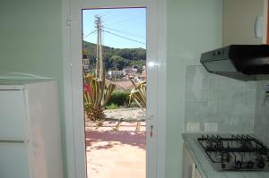 a kitchen with a view of a patio through a door at Solanha monolocale n.4 in Cavo