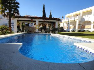 a large swimming pool in front of a building at AT Almoraide Rooms Suites in Nerja
