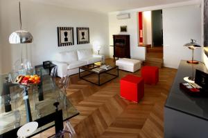 een woonkamer met een witte bank en rode stoelen bij R&B Santo Stefano in Bologna