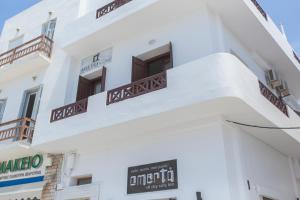 un edificio blanco con un cartel. en Amalthia Luxury Studios en Naxos