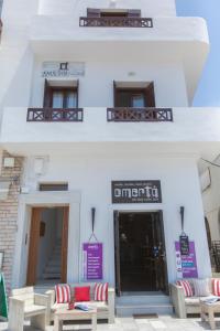 un edificio blanco con bancos delante en Amalthia Luxury Studios, en Naxos Chora