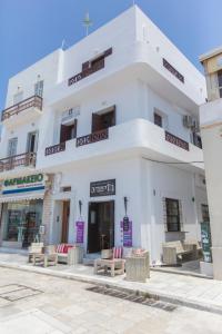 un edificio blanco con bancos delante en Amalthia Luxury Studios, en Naxos Chora