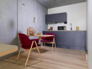 cocina con mesa y sillas en una habitación en Ohboy Hotell, en Malmö