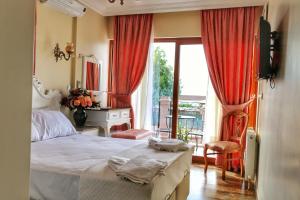 a bedroom with a bed and a desk and a window at Stone Hill Hotel in Ayvalık