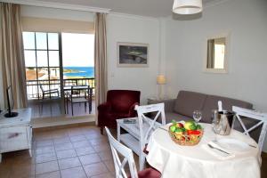 ein Wohnzimmer mit einem Tisch und einer Obstschale darauf in der Unterkunft Apartamentos Vista Real in Alcaidesa