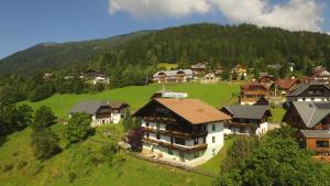 a large house on a green hill with houses at Feichterhof in Bad Kleinkirchheim