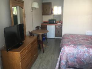 1 dormitorio con 1 cama, TV y mesa en Surf Haven Motel, en North Wildwood