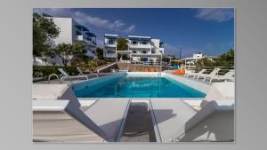 basen z krzesłami przed budynkiem w obiekcie Milatos Village Cretan Agrotourism Hotel w mieście Milatos