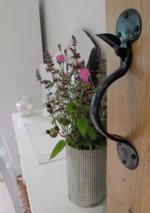 eine Tür mit einer Vase mit Blumen darin in der Unterkunft Pippin Heath House B&B in Holt