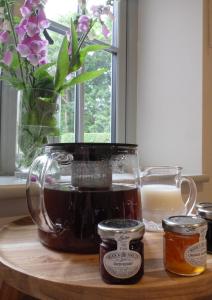 a table with a jar of honey and a vase of flowers at Pippin Heath House B&B in Holt