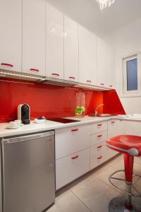 アテネにあるModern and Cozy Apartment in the centre of Athensの白いキャビネットと赤い壁のキッチン