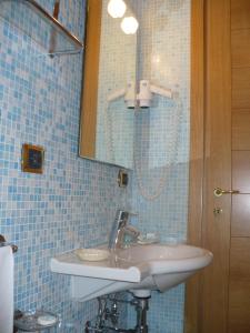 un baño con lavabo y espejo en Hotel Villa Carolina, en Isquia