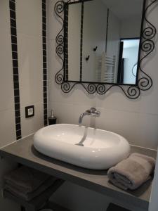 a bathroom with a white sink and a mirror at Les Marguerites in Champdolent +15 photos