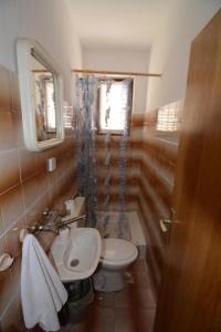 a bathroom with a sink and a toilet and a mirror at Garden Apartment Braut in Kornić +104 photos