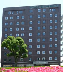 um hotel com uma árvore em frente a um edifício em Hotel Nishimura em Fuji