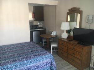 a bedroom with a bed and a flat screen tv at Surf Haven Motel in North Wildwood
