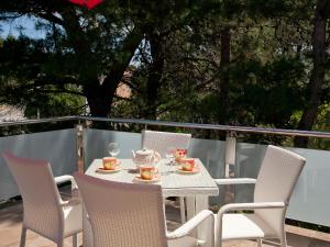a table with chairs and a tea set on a patio at Apartments Marija in Vir