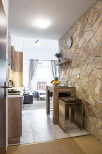 a kitchen with a table and a stone wall at Apartment Jelena1 in Tatranská Lomnica