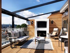 einen Balkon mit Sofa und Kamin in der Unterkunft The Marylebone Hotel in London