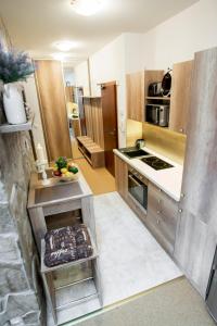 a kitchen with wooden cabinets and a stove top oven at Apartment Jelena1 in Tatranská Lomnica +18 photos