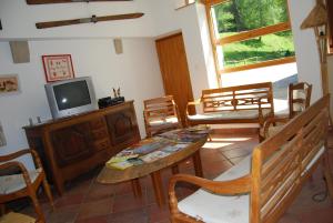 a living room with a tv and a table and chairs at Chambre d'hôtes Kieffer Le Grand Bienfaisy in Remiremont