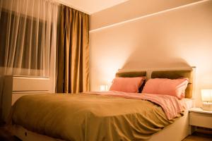 ママイア・ノルドにあるApartament Harmony 1 Mamaia Satのベッドルーム1室(ピンクの枕が付くベッド1台、窓付)