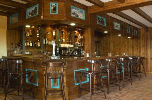 um bar com bancos num quarto com paredes de madeira em Hotel Garabatos em Navarredonda de Gredos