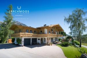 a large house with a large driveway at Appartements Lärchmoos in Ramsau am Dachstein