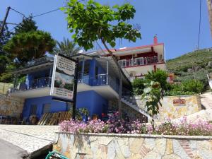 a blue house with flowers in front of it at Elena Rista Studios in Parga