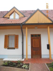 Casa blanca con puerta y ventanas de madera en Nagelj 1 en Martjanci