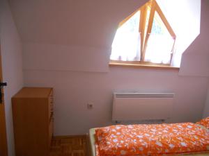 a small bedroom with a bed and a window at Nagelj 1 in Martjanci