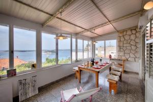 a dining room with a table and chairs and windows at Bellevue Apartment Hvar in Hvar