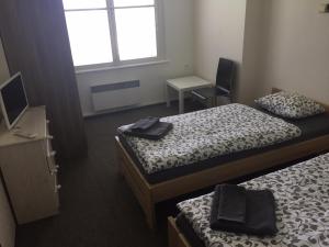 a bedroom with two beds and a desk and a window at Vila Háj in Úsov