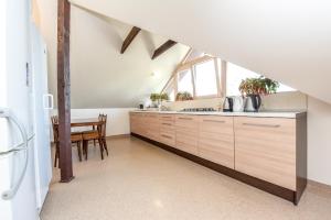 an attic kitchen with wooden cabinets and a table at Holiday house KNP in Palanga