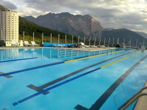 una grande piscina blu con montagne sullo sfondo di Hotel Sud Ovest a Sestriere