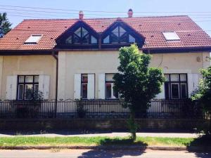 dom z czerwonym dachem i czarnym płotem w obiekcie Horváth Apartmanház w mieście Kaposvár