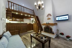 - un salon avec un canapé et une cheminée dans l'établissement Aronia Villa, à Imerovigli