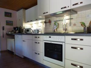 a kitchen with white cabinets and a stove top oven at Ferienhaus Katharina in Nothweiler