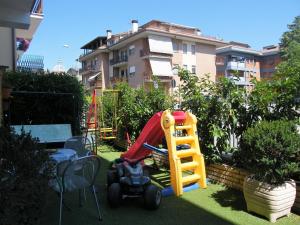 un pequeño patio con un parque infantil con un tractor de juguete en B&B Domus Benedicta en Asís