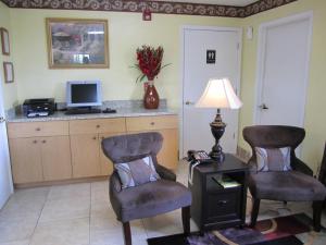 a living room with two chairs and a desk with a computer at Western Inn & Suites in Douglas