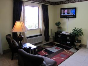 a living room with a couch and a table and a television at Western Inn & Suites in Douglas