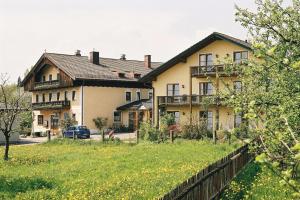 a house with a fence in front of a yard at Gasthaus - Hotel Alt Fürstätt in Rosenheim