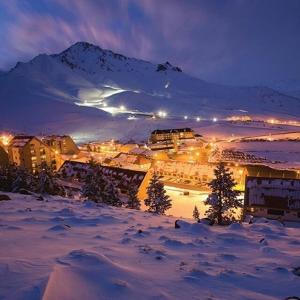 una ciudad en la nieve por la noche con una montaña en Rodas - Las Leñas en Las Lenas