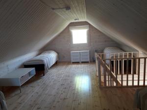 a attic room with two beds and a window at Ristijärven Pirtti Cottage Village in Ristijärvi