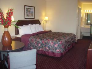 ダグラスにあるWestern Inn & Suitesのベッドと花瓶が備わるホテルルームです。