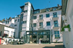a woman standing in front of a large white building at Hotel Stadt Emmerich in Emmerich
