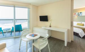 a room with a desk, chair and a television at GHL Corales de Indias in Cartagena de Indias
