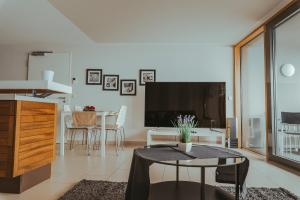 ein Wohnzimmer mit einem Tisch und einem TV in der Unterkunft Apartments im s'Wirthaus in Friedrichshafen