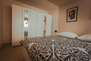 ein Schlafzimmer mit einem Bett mit einer schwarzen und weißen Decke in der Unterkunft Apartments im s'Wirthaus in Friedrichshafen